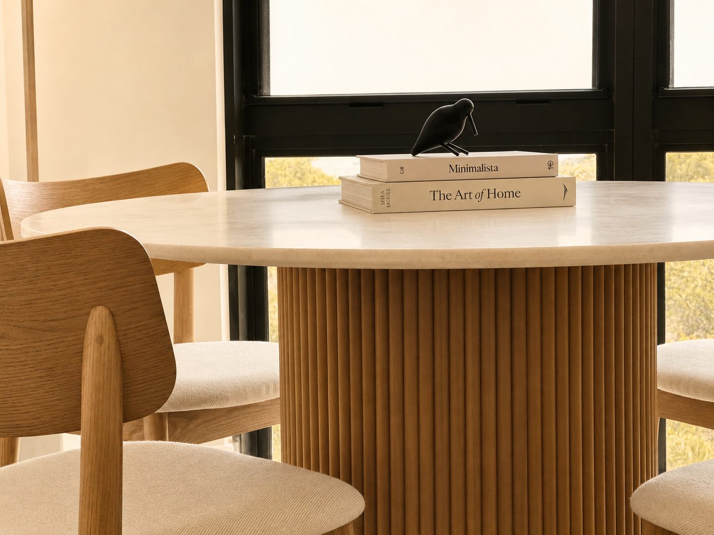 Mesa de comedor redonda de madera con sillas y figura decorativa