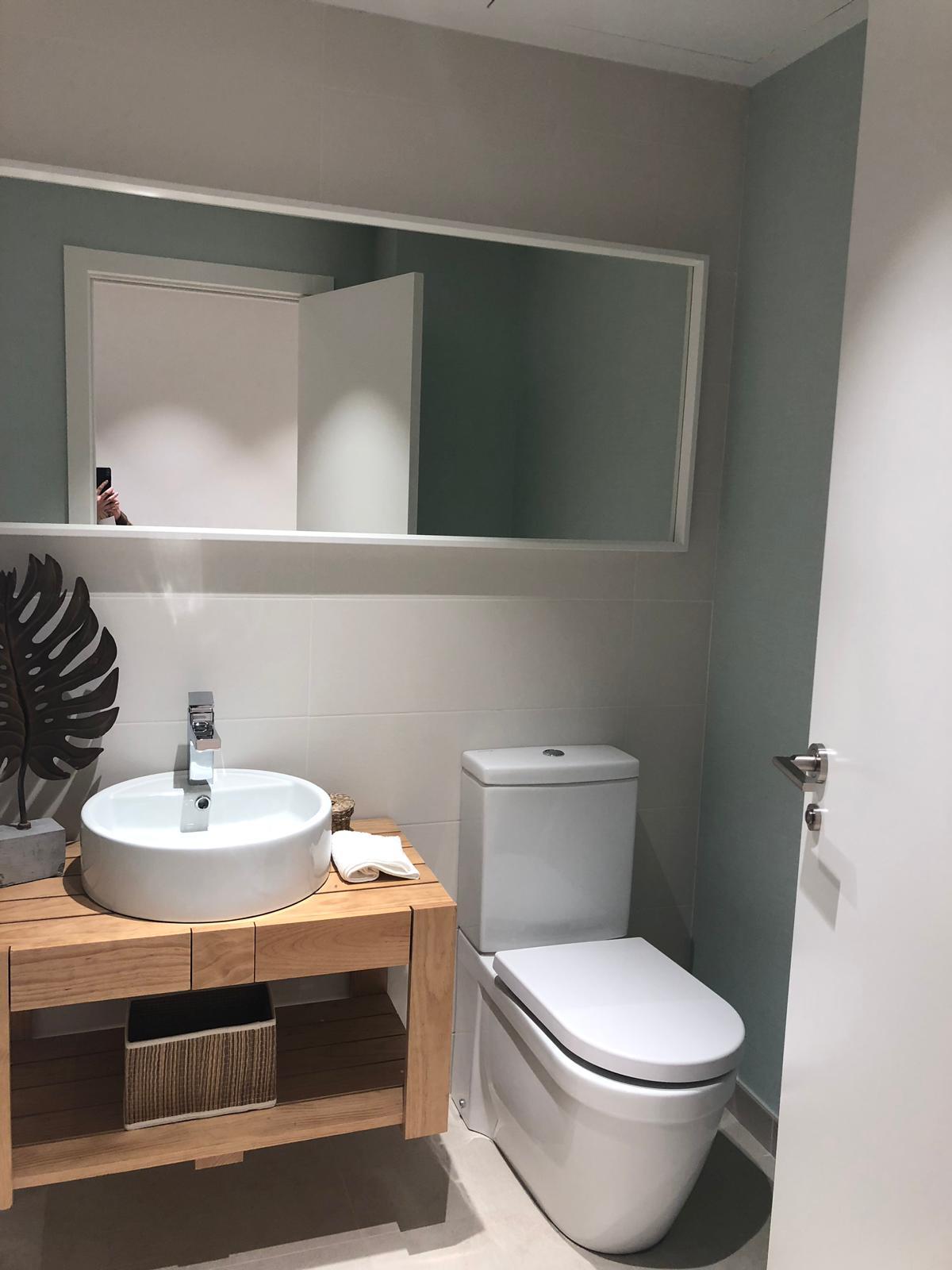 Baño reformado con mueble de madera maciza suspendido y grifería en cromo
